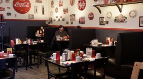 Two patrons at a booth in Little Dipper Diner. Several empty tables and booths surround the patrons