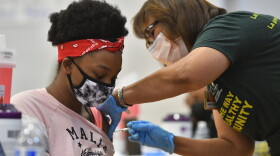 University Health volunteer Valerie Chow, a retired physician, administers a COVID-19 vaccine to a teenager in June. On Tuesday the Center for Disease Control recommended children ages 5 to 12 can receive a low-dose version of the Pfizer-BioNTech COVID-19 vaccine.