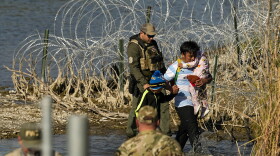  Migrants are taken into custody by officials at the Texas-Mexico border in Eagle Pass, Texas.