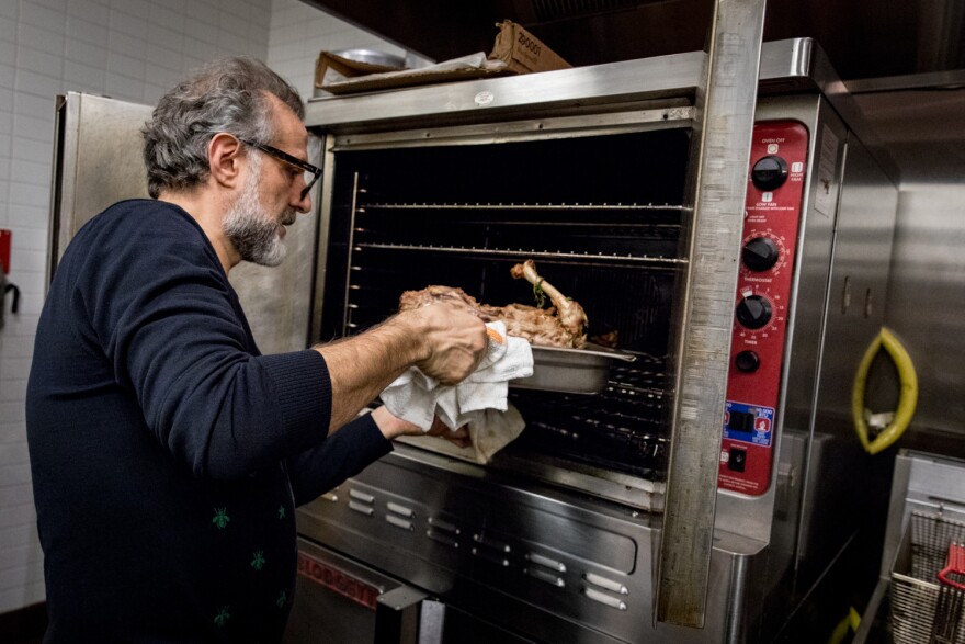 Bottura puts a turkey carcass, nestled on a baking sheet with veggie scraps, in the oven to roast and unlock its flavor. After about 45 minutes, the bones go in water to boil to become the broth for passatelli.