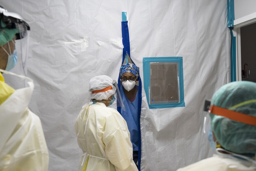 Members of the medical staff communicate through a barrier in the COVID-19 ICU at the United Memorial Medical Center in Houston on July 2. COVID-19 cases and hospitalizations have ballooned since Texas reopened, pushing intensive-care wards to full capacity and sparking concerns about a surge in fatalities.