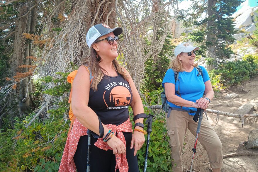 Lead hiker Cherie Zajdzinski, left, and New York transplant Cindy Prassas laugh with fellow society members at Lake Mary, Sept. 15, 2024.