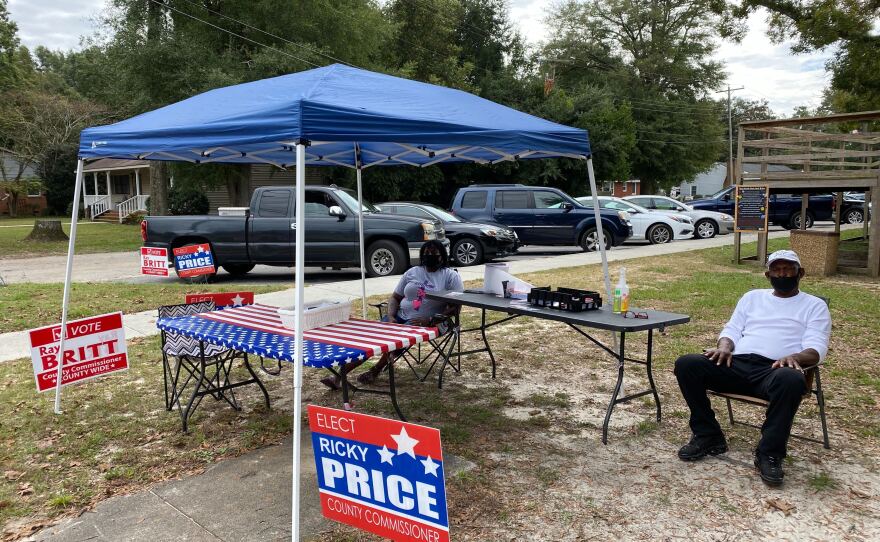 Cynthia and Levi Roberts sit at a booth for local candidates in Elizabethtown, Bladen County, on the first day of early voting.