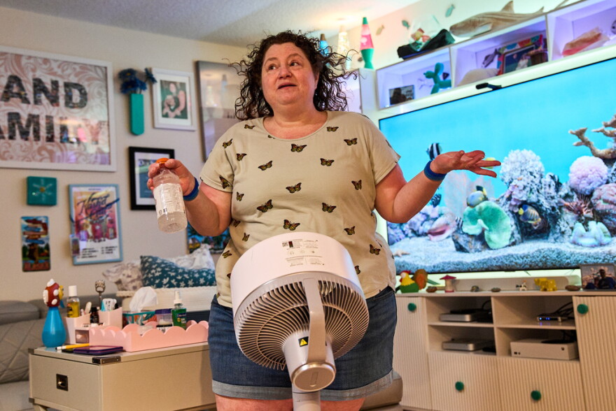 Tracy Rand uses a fan to help with her severe menopause symptoms, brought on after a surgery to remove her ovaries, at her home in Leesburg.