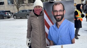 A protestor holds a sign of 37-year-old nurse Alex Pretti, who was killed in Minneapolis over the weekend. (Photo: Maxwell Howard/IPR News)