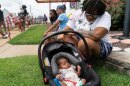 LaWanda Felder and her daughter Aza Ali Felder wait in line to apply for assistance at a disaster recovery center in Hazelwood Monday, Aug. 15. Felder's basement filled with floodwater during record-breaking rainfall last month.