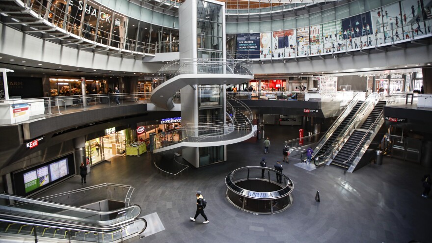 A pedestrian passes a nearly empty subway and retail complex in lower Manhattan as businesses are closed due to coronavirus concerns on Monday. [John Minchillo / AP]