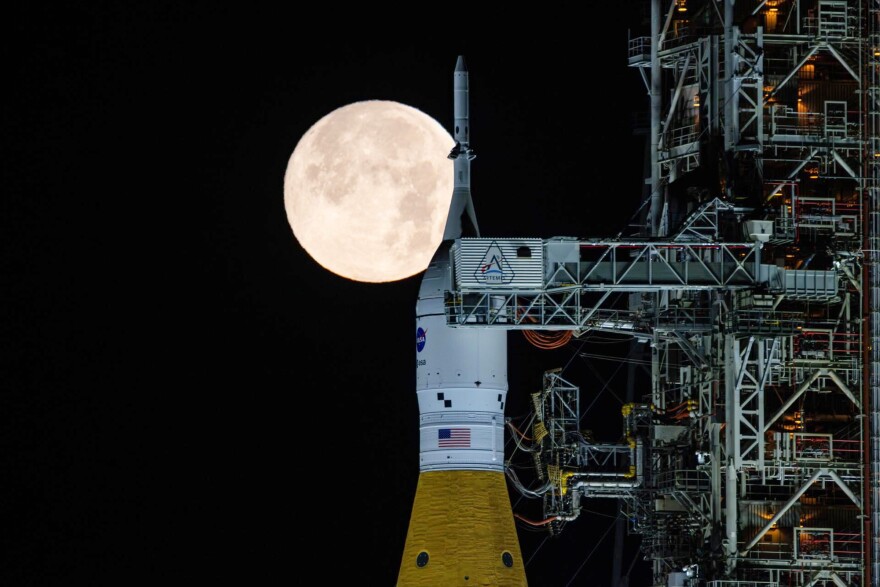 A full moon is seen shining over NASA’s SLS (Space Launch System) and Orion spacecraft, atop the mobile launcher in the early hours of Sunday, Feb. 1, 2026, at NASA’s Kennedy Space Center in Florida. (Sam Lott/NASA via AP)