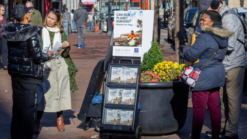  A woman shares Jehovah's Witnesses' literature with a passerby on a street corner