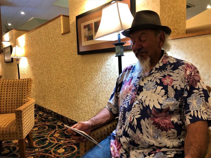 Sergio Maldanadp sits in a patterned hotel lobby.