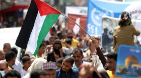 A Yemeni protester waves a Palestinian national flag during a demonstration held in Yemen's third city Taez to denounce the ongoing Israeli air strikes on the Gaza Strip.
