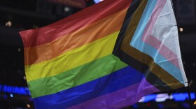 A pride flag is waved during an NBA basketball game.
