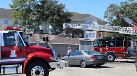 Fire trucks are next to the restaurant as we see a hole has been burned through the roof
