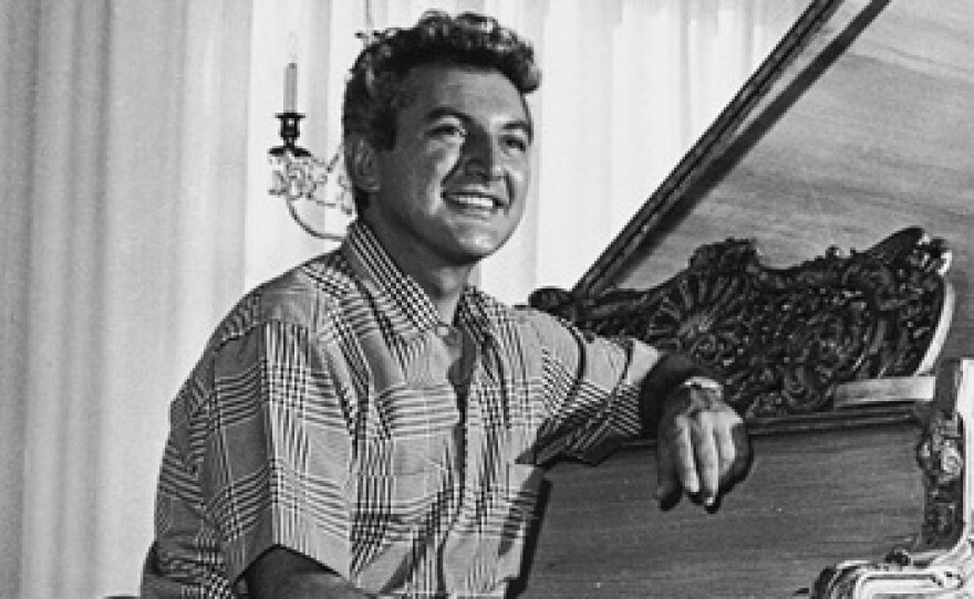 Liberace sits at a gold-leafed piano in the living room of his then-new Hollywood mansion in November 1961.