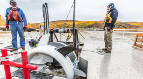 ACEP research engineer Jack Schmid, left, and research professional Paul Duvoy help position the Oceana river turbine during testing in the Tanana River near Nenana conducted in 2016 by ACEP's Hydrokinetic Energy Research Center.