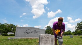 Lisa McNair arranges flowers on the grave of her late sister, Carol Denise McNair, on Monday, June 1, 2026, in Birmingham, Alabama.