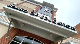 Exterior photo of a brick building with glass entry and sign above the door that reads "Kansas City Board of Education.