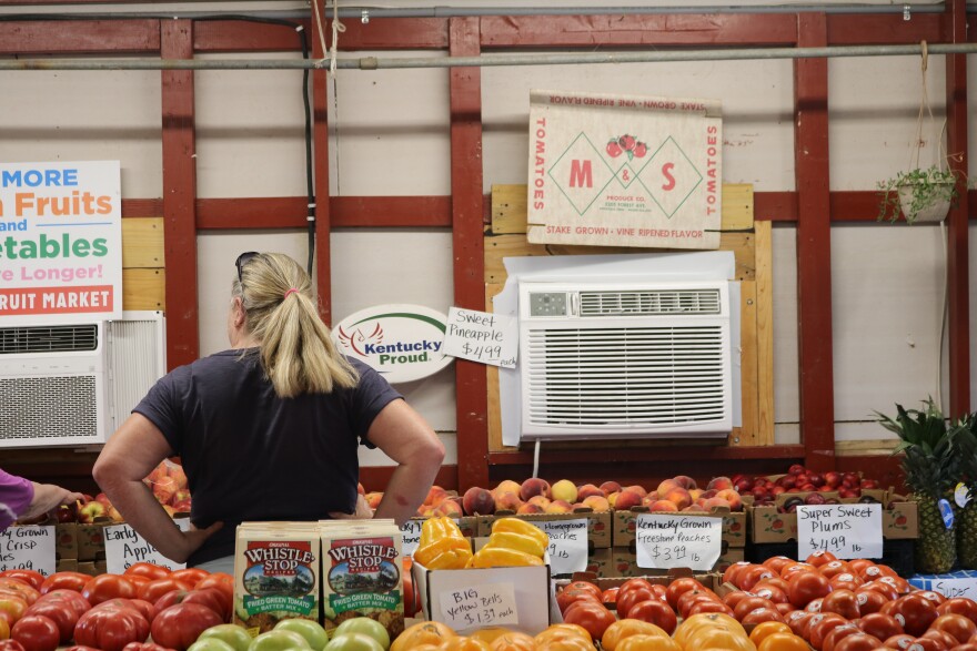 Kelly Ratliff, owner of Kelly's Fruit Market, helps a customer pick out apples for baking amid a variety of fruit grown in the region on August 4, 2026.