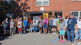 The local church's bucket brigade poses proudly in front of the trailer packed with their handiwork.
