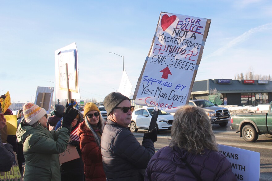 Steve Ford (center) holds a sign at the intersection of the Sterling and Kenai Spur highways to protest federal immigration operations on Sunday, Feb. 1, 2026 in Soldotna, Alaska.