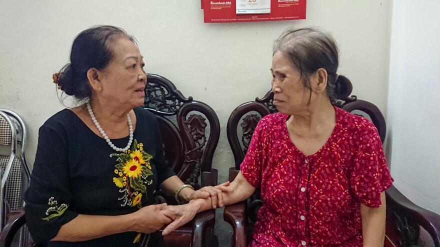 Dao sits with club member Ms. Báu, who is seeking financial assistance from the club. Some funds are available to members in need.