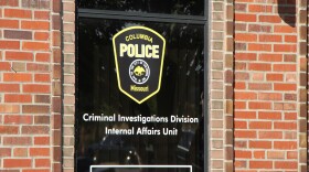 A close up of the window of the Columbia Police Department with a sign that reads "Criminal Investigations Division Internal Affairs Unit"