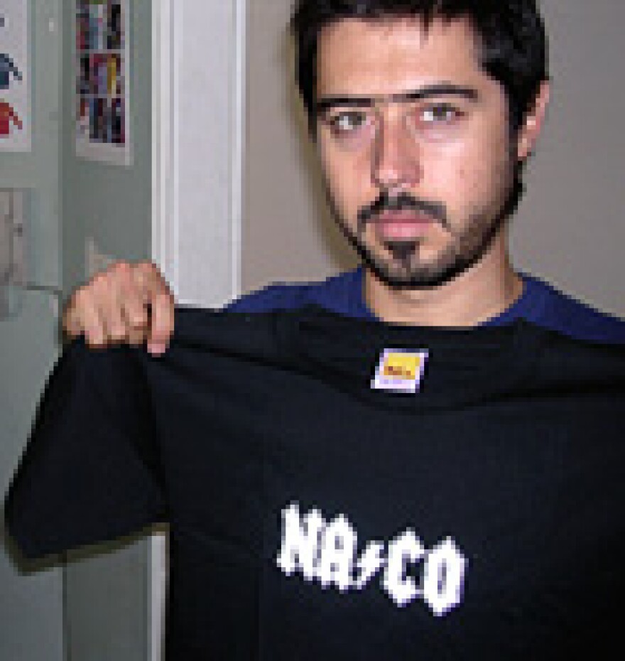 Carlos Meza, co-owner of a t-shirt company, displays one of his naco brand t-shirts.