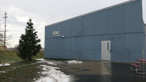 blue building with no windows that says 500 North Edwards, melting snow and a picnic table
