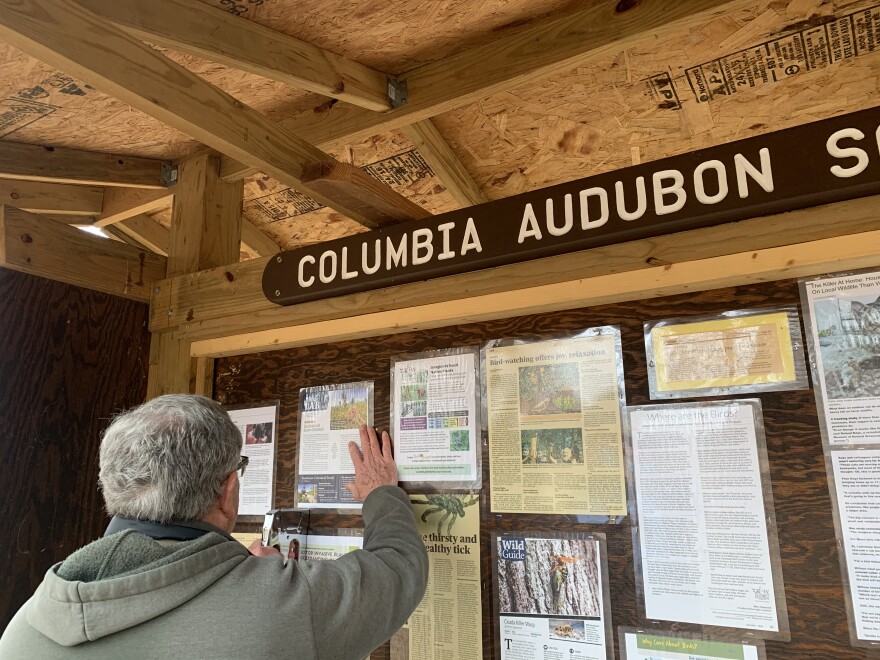 Bill Mees stapling new informational articles on the CANS trailhead kiosk for visitors to read in Columbia, MO on Feb. 26.