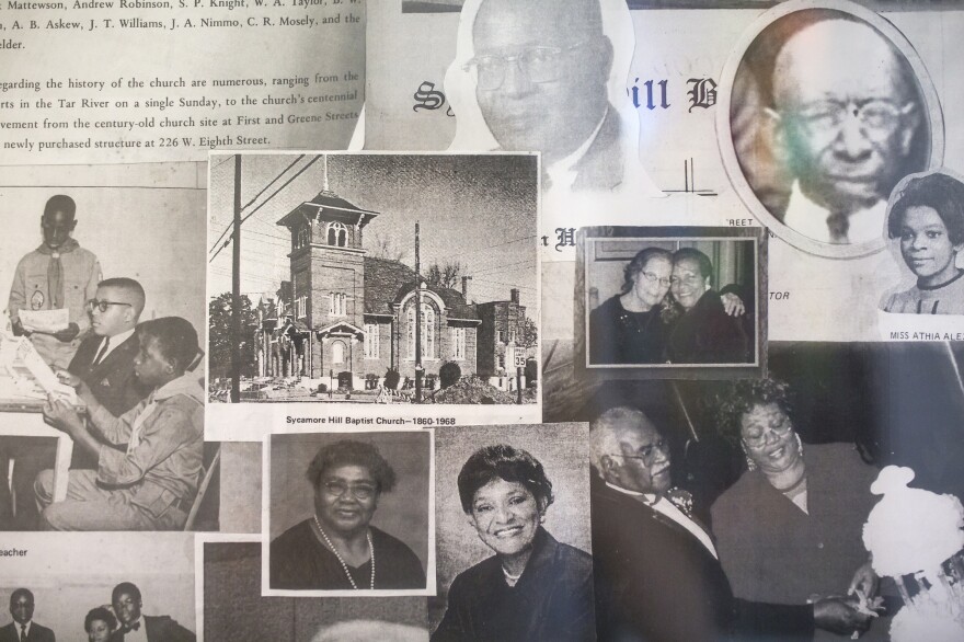 Images of former congregants as well as an image of the church's former building hang on the wall at Sycamore Hill Missionary Baptist Church.