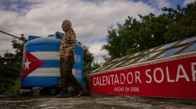 Felix Jose Morfi stands by his solar-powered water heater system he set up on his home's roof in Regla, Havana province, Cuba, Thursday. Jan. 29, 2026. (AP Photo/Ramon Espinosa)