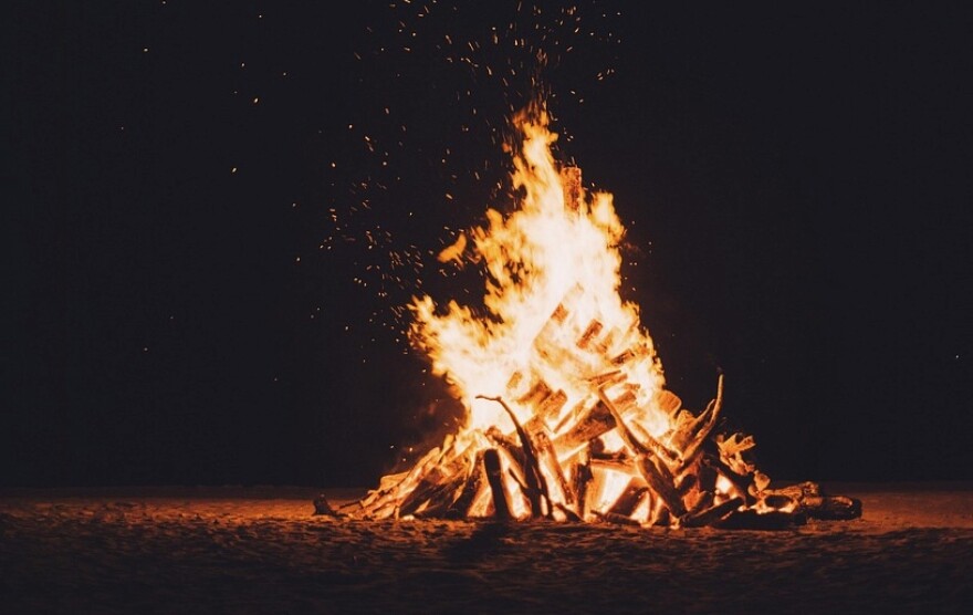 a bonfire lights up a night scene