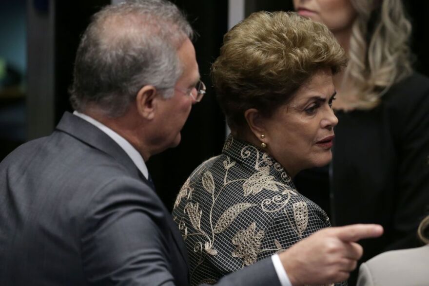 Then Brazilian President Dilma Rousseff leaves the Senate chambers after the vote to impeach and removal from office in August 2016. Behind her is Senate leader Renan Calheiros.