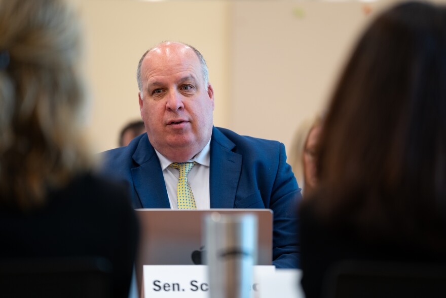 A man wearing a suit sits at a table