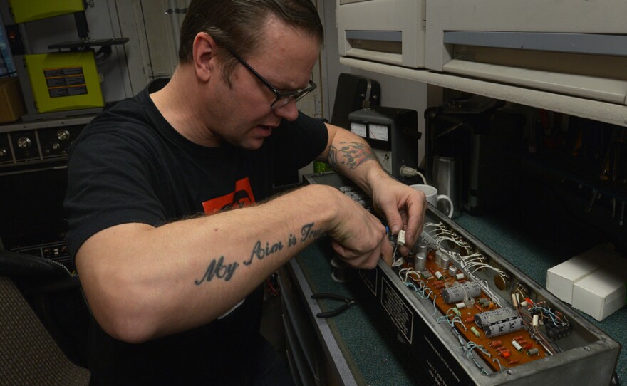 Tannar Brewer repairs electronics on an amplifier in a north Seattle workshop. Brewer is a partner in an instrument repair business with Chris Lomba.