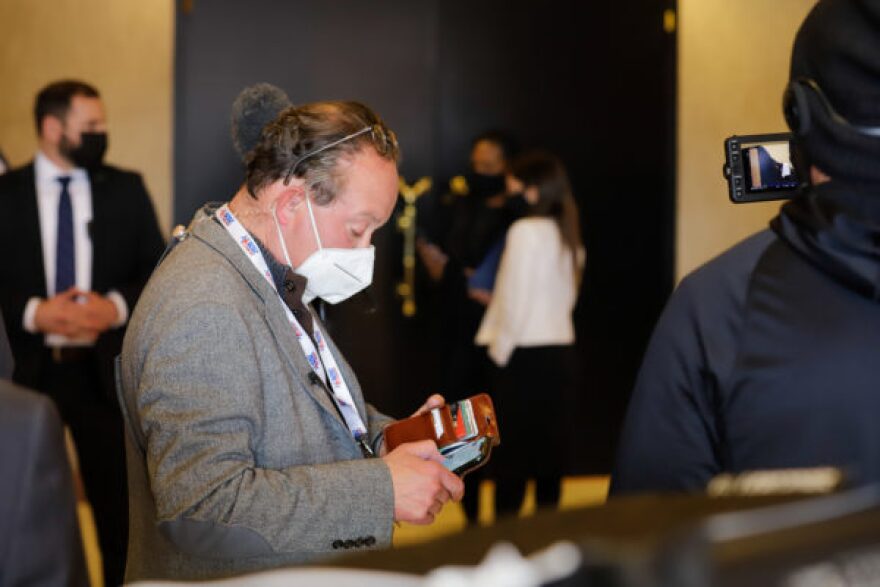 a person with a mask on looks at their phone