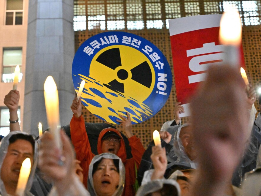 South Korea's main opposition Democratic Party members hold electric candles and a sign reading "No Fukushima nuclear contaminated water!" during a rally against Japan's plan on Wednesday. Other Pacific nations are also worried by the release.