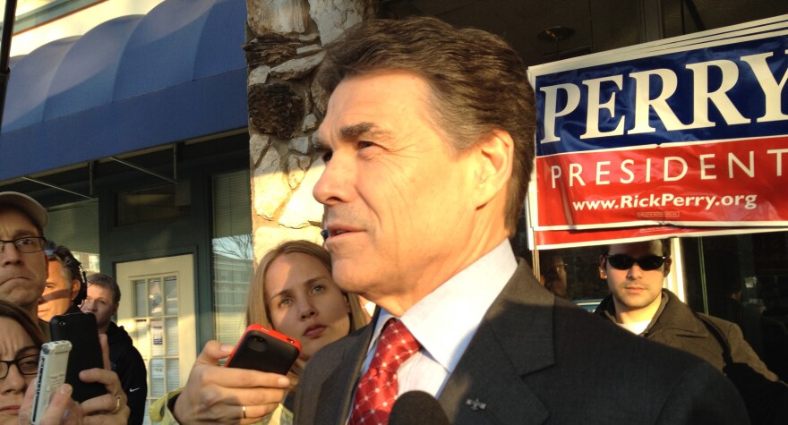 Rick Perry speaks to reporters at the Veterans for the Strong America forum in Des Moines.