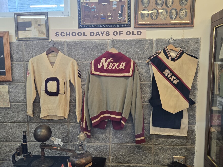 An exhibition on local schools with historic uniforms from Nixa.
