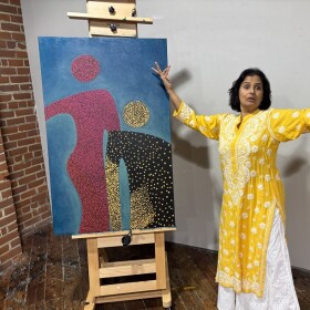 Multidisciplinary artist Lakshmi Sriraman demonstrates traditional dance next to one of her paintings from the series Us and Us.
