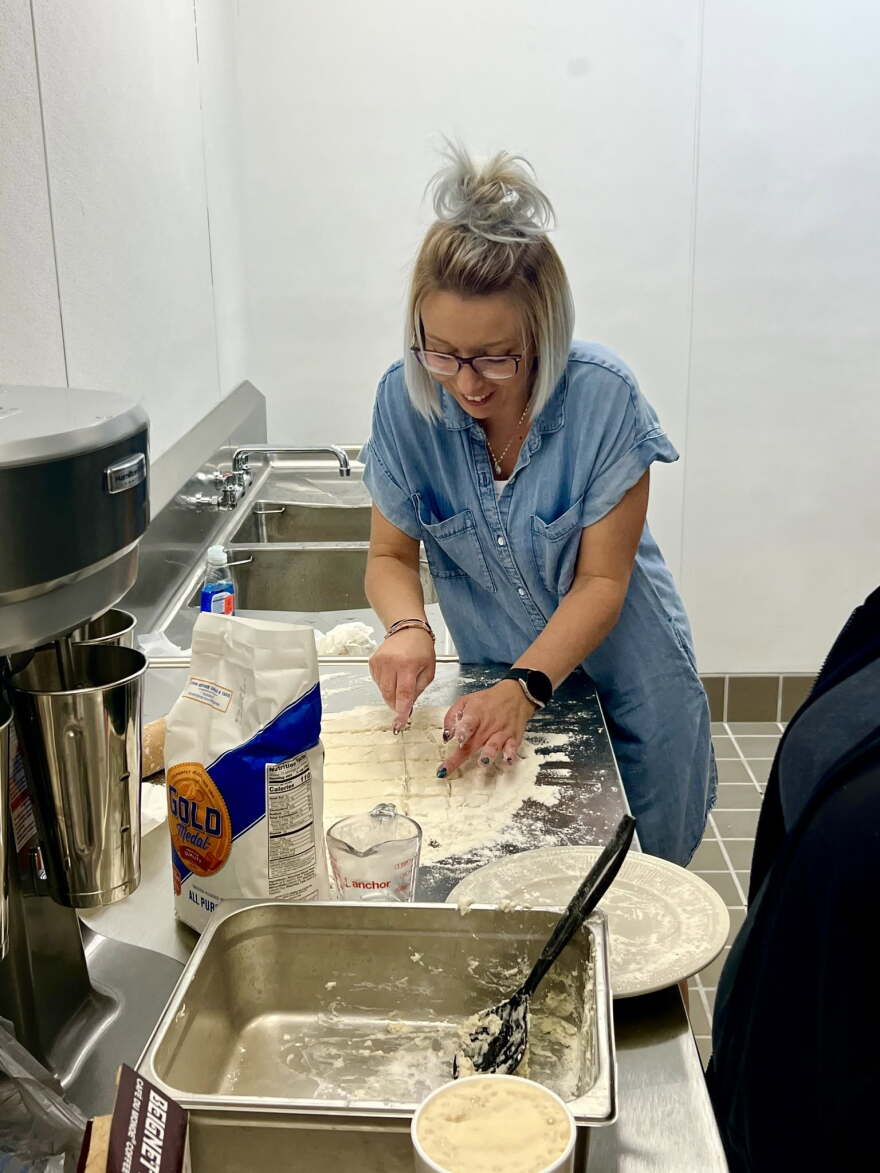 A woman bakes in an kitchen.