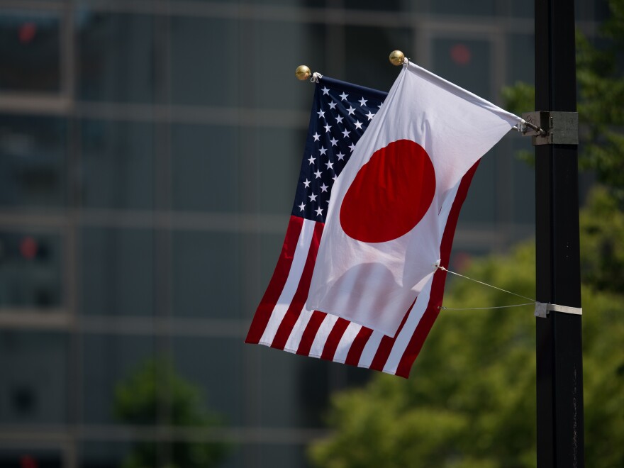 A Japanese and a U.S. flag are seen next to the Hiroshima Peace Memorial in Hiroshima on Friday.