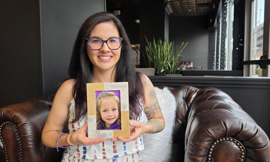 Rebecca Reed holds a photo of her daughter, Isla Rose Melucci. Isla died in her sleep from Sudden Unexplained Death in Childhood in March.
