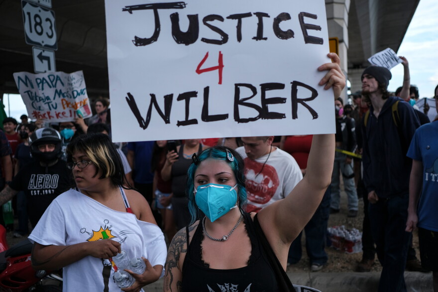People speak during a demonstration where a man was shot in his vehicle by an ICE officer, Sunday, Sept. 20, 2026, in Austin, Texas. (AP Photo/Joel Angel Juarez)