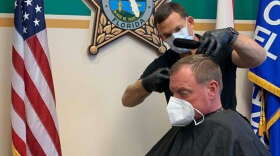 Leesburg barber David Randall gives Lake County Sheriff Peyton Grinnell a haircut at the Sheriff's Office in this photo posted to Facebook. Photo: LCSO