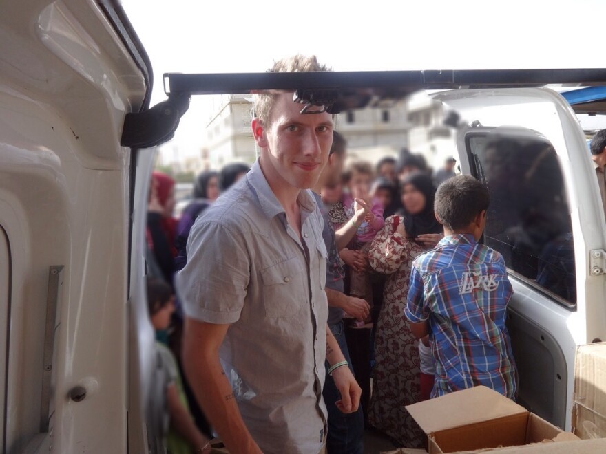 Abdul-Rahman Kassig, who was formerly known as Peter, is shown with a truck filled with aid supplies for Syrian refugees. The American aid worker was seized by the Islamic State in October 2013 and subsequently killed by the group, which released a video Sunday of his beheading.