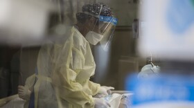 A health care worker treats a patient in the covid-19 intensive care unit at Freeman Hospital West in Joplin, Missouri, on Aug. 3.