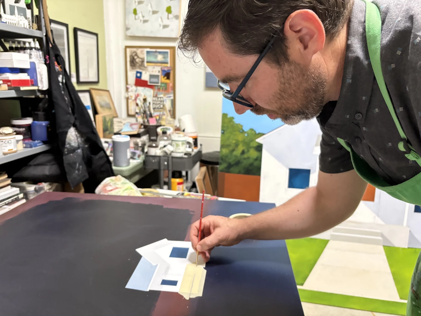 Person painting a house on a canvas