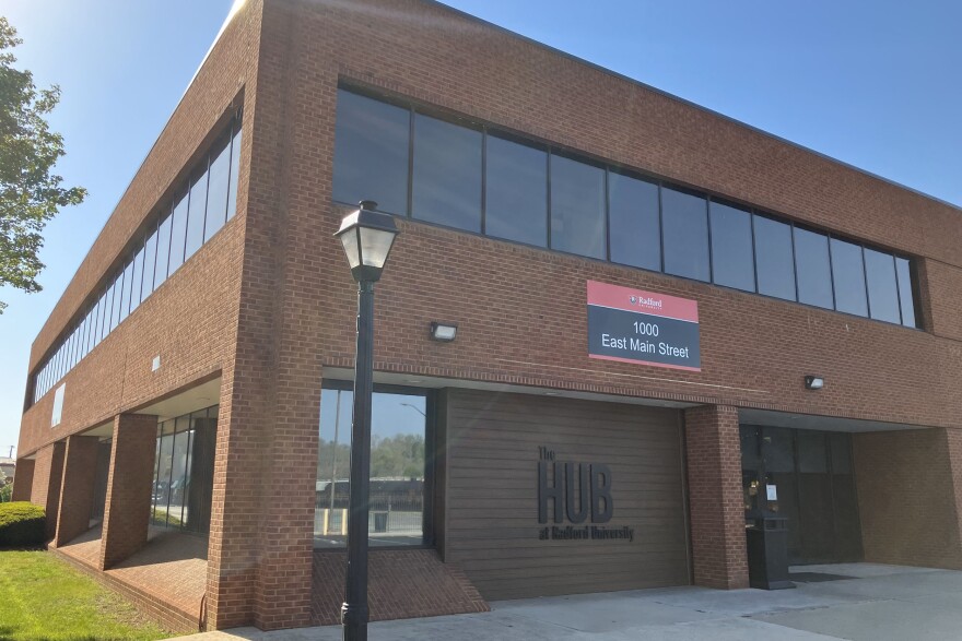 A brown brick building  that has the words "The Hub at Radford University" written in black letters.