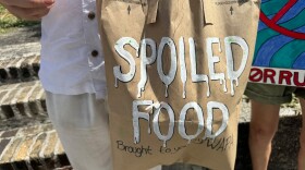 Pictured: A protester displays a brown paper bag labeled “Spoiled Food — Brought to You by WAPA” during a demonstration outside the Legislature's Capitol Building in St. Thomas, where residents expressed frustration over food losses and other hardships caused by recent power outages in the St. Thomas/St. John district.